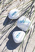 Beach holiday - stones with writing lying in the sand