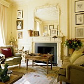 An elegant living room with a coffee table and a sofa in front of a fireplace with a decorated mirror above the mantelpiece