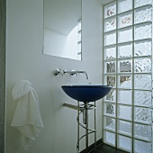 Blaue freistehende Waschschüssel vor Glasbausteinwand und Wandarmatur unter Spiegel