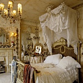 Schlafraum im Rokokostil - Himmelbett mit weisser Bettwäsche und Baldachin aus Spitzenstoff
