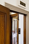 An open living room door with a view of a hallway and another door