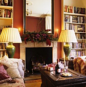Atmospheric lighting in a room with a fireplace and a built-in bookshelf in front of a red wall