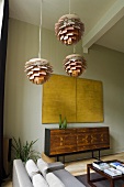 Bauhaus-style ceiling lamps and a yellow picture hanging above a designer sideboard