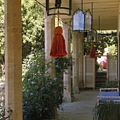 Terrasse mit Steinsäulen und Laternen an der Decke mit farbigen Quasten