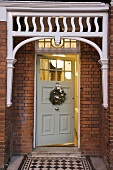 Wohnhaus in London - Hauseingang in Ziegelfassade mit Weihnachtsdeko an der weissen Haustür