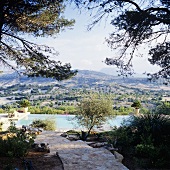 A natural stone path in a Mediterranean garden with a pool and an impressive view of the Spanish landscape