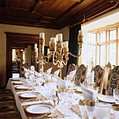 A festively laid table with silver candle sticks in the dining room of a country house