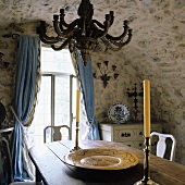 Old arched ceiling in rustic dining room and blue curtains as the window