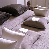 A symmetrical arrangement of cushions on a bed