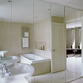 A wash basin next to a mirrored cabinet in a bathroom