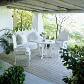 weiße elegante Terrassenmöbel im spanischen Stil auf Holzterrasse eines Ferienhauses
