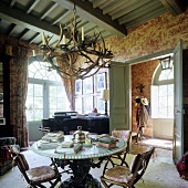 Living room with stone table and antler chandelier in a French country home