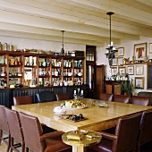 Esstisch mit braunen Ledersesseln unter rustikaler Holzdecke eines südafrikanischen Landhauses