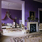 Kaminraum mit offenem Durchgang zum Wohnraum mit lila Tapete und goldenem Ornamentmuster