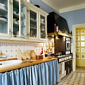 A kitchen in a country house with blue walls