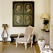 A Rococo armchair in front of portraits with dark backgrounds