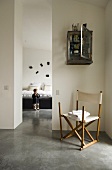 A canvas chair in an anteroom and a narrow doorway with a view of a child in a bedroom