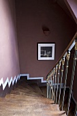 A steep flight of wooden stairs and a dark red wall