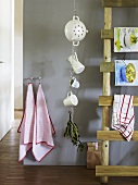 An arrangement in a kitchen - crockery hanging against a grey wall