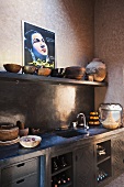 Corner of a Mediterranean kitchen - bowls on a shelf and a work surface with dark grey fitted cupboards