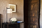 Tischlampe auf Beistelltisch und Blick auf geöffneter Zimmertür in rustikalem Stil