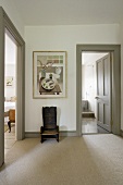 An anteroom with a rustic wooden chair and a view through open doors