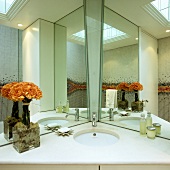 Spiegelkabinett im Badezimmer - in die Ecke platzierter Waschtisch mit weisser Steinplatte