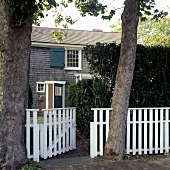 A detached house with a white garden fence