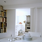 Crockery being tidied - a view through to a kitchen with an open dishwasher