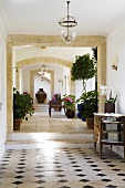 A hallway in a Mediterranean country house with stone archways and a patterned tiled floor