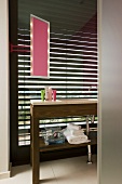 A wooden washstand in a bathroom with closed blinds