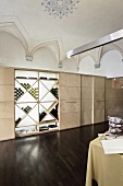 A designer restaurant with a vaulted ceiling - a modern built-in cupboard with a wine rack and a dark wooden floor