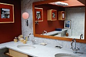 Waschtisch mit Marmorplatte und gerahmtem Spiegel in Badezimmerecke
