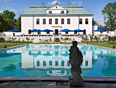 A pool in front of a renovated palace with a terrace