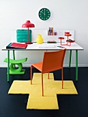 Schreibtisch mit orangefarbenem Stuhl auf gelbem Teppich