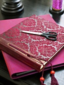 Photo album with red flora pattern and scissors