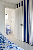 Room with blue and white striped curtain and open door with a view into the foyer