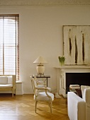 Upholstered chairs and sofa arranged around coffee table in front of fireplace