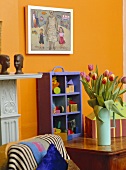 Vase of pink tulips on wooden table in yellow room