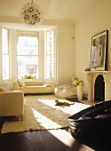 Light, sitting room with neutral furnishings and large windows