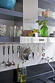 Utensils on hanging on bar above kitchen sink