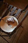 A slice of cake on a plate on a wooden chair