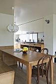 Pendant light above wooden table in modern open plan dining room