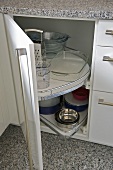 Kitchenware on storage shelves in modern kitchen unit