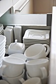 White tableware stored in open drawer