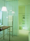 Hotelbad mit transparenter Glaswand und geschlossenem Vorhang