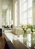 Vases of white tulips on clear plastic table