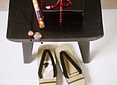 Japanese flip flops under black wooden Japanese table, box, wrapped incense sticks