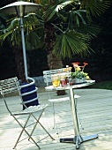Garden furniture and outdoor heater on wooden decking.