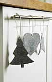 Christmas decorations made of gray felt hanging on a stainless steel rod